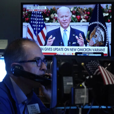 FILE - President Jose Biden appears on a screen as trader Mark Puetzer works on the floor of the New York Stock Exchange, Nov. 29, 2021. (AP Photo/Richard Drew, File)