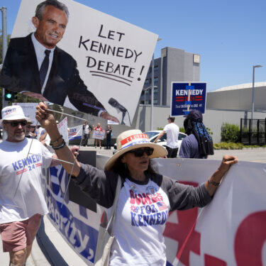 Supporters of Presidential candidate Robert F. Kennedy Jr. protest outside the Warner Bros. Studios in Burbank, Calif., Friday, June 21, 2024. (AP Photo/Damian Dovarganes)