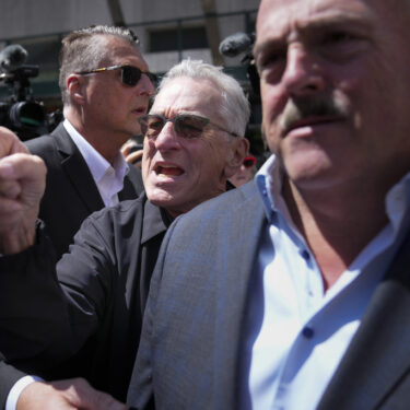 Robert De Niro, center, argues with a Donald Trump supporter after speaking to reporters in support of President Joe Biden across the street from Trump's criminal trial in New York, Tuesday, May 28, 2024. (AP Photo/Seth Wenig)